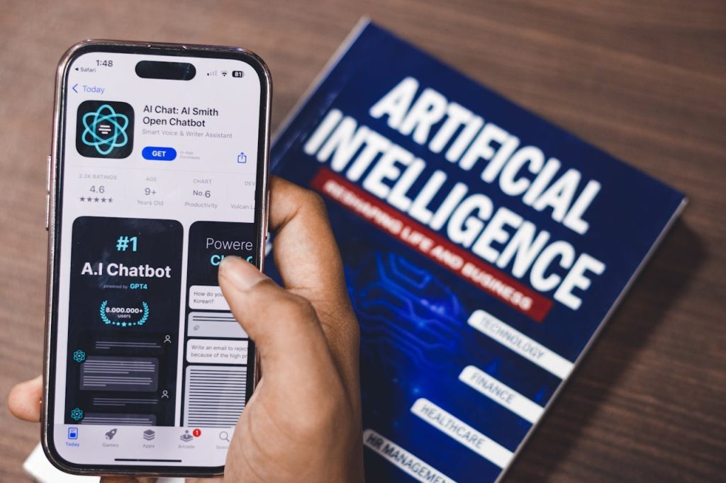 pexels photo 16380906 Smartphone displaying AI app with book on AI technology in background.