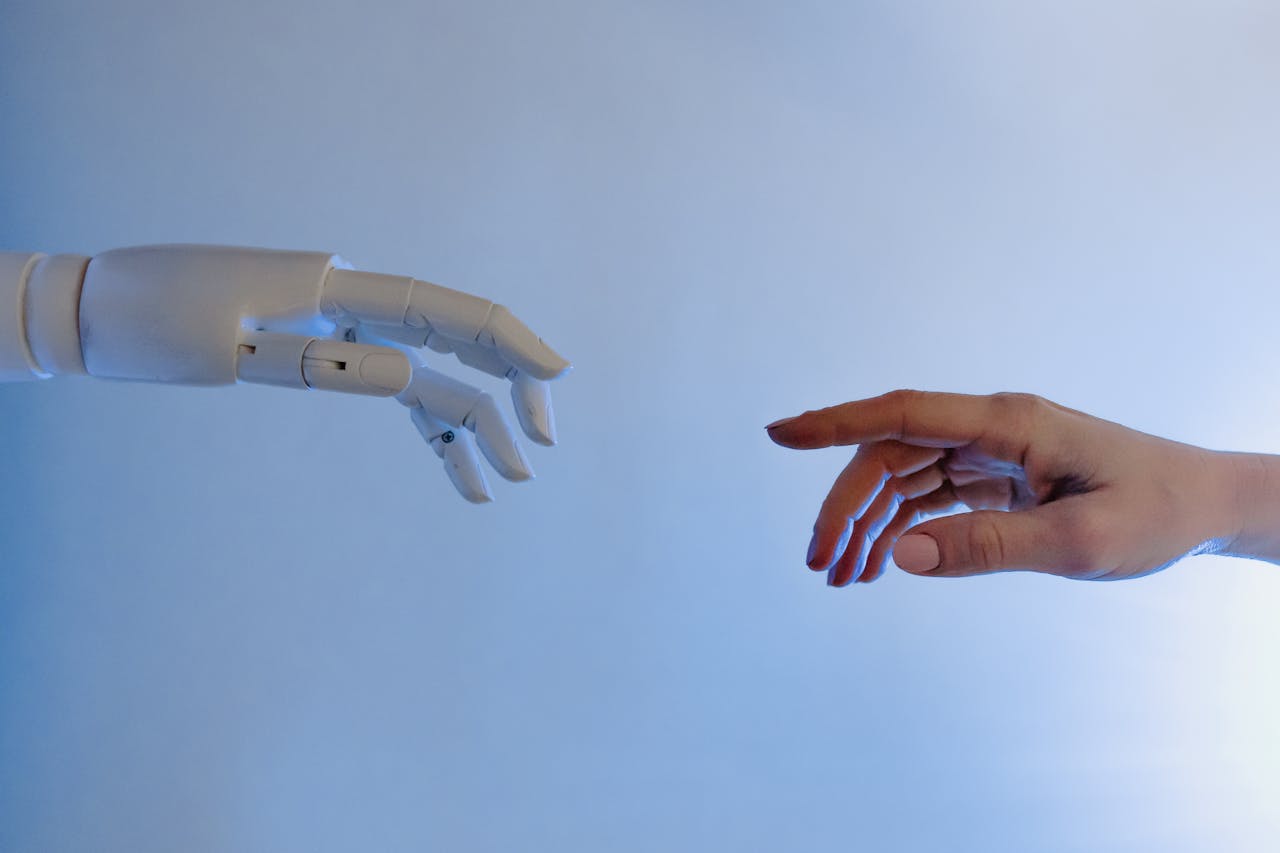 services-01 A human hand reaching towards a robotic hand symbolizing technology and connection.